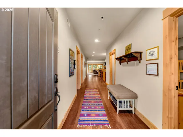 a hallway with a large mirror and wooden floor