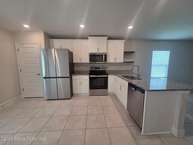 a kitchen with a stove a refrigerator and a sink