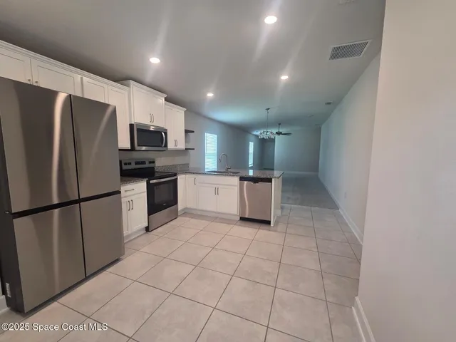 a kitchen with stainless steel appliances a refrigerator sink and microwave