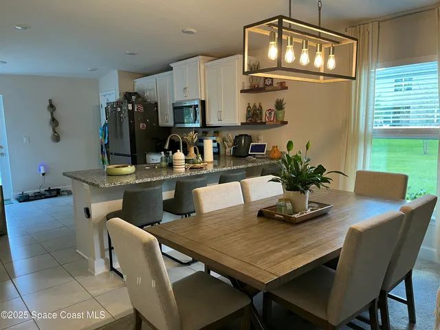 a view of a dining room with furniture and chandelier