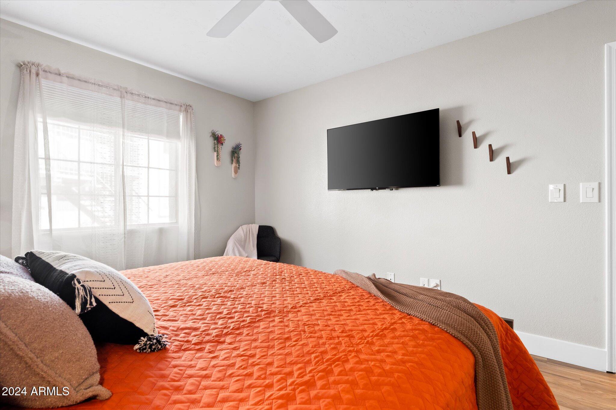 533 West Guadalupe Road, Unit 1063 Mesa, AZ 85210 - Photo 33 of 57 a bedroom with a bed and a flat screen tv