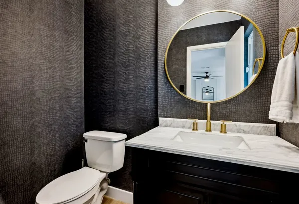 a bathroom with a sink a toilet and a mirror