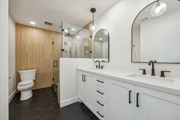 a bathroom with a double vanity sink mirror and toilet