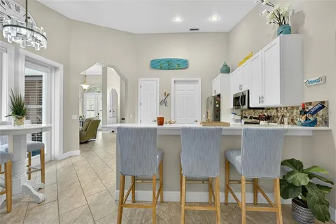 a kitchen with stainless steel appliances kitchen island granite countertop a table and chairs in it