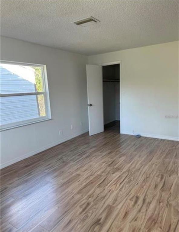 7149 Carmel Avenue New Port Richey, FL 34655 - Photo 11 of 13 an empty room with wooden floor and windows