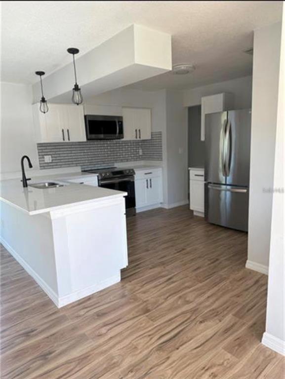 7149 Carmel Avenue New Port Richey, FL 34655 - Photo 3 of 13 a kitchen with a sink wooden floor and a refrigerator