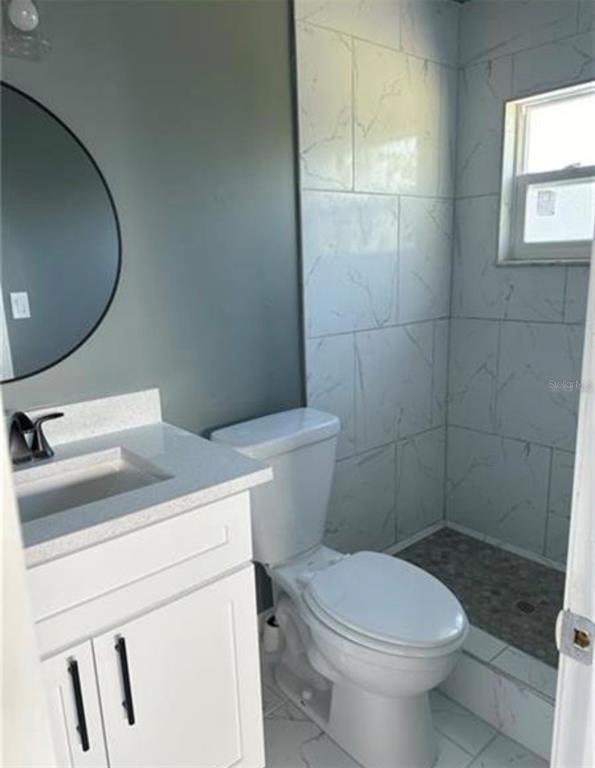 7149 Carmel Avenue New Port Richey, FL 34655 - Photo 5 of 13 a white toilet sitting next to a bathroom sink