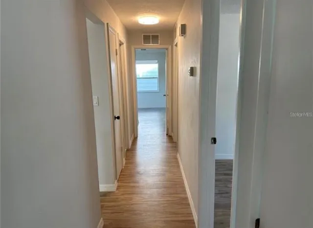a view of a hallway with wooden floor