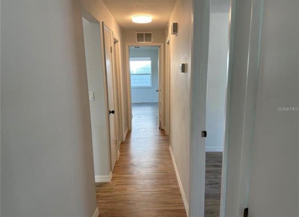 7149 Carmel Avenue New Port Richey, FL 34655 - Photo 8 of 13 a view of a hallway with wooden floor