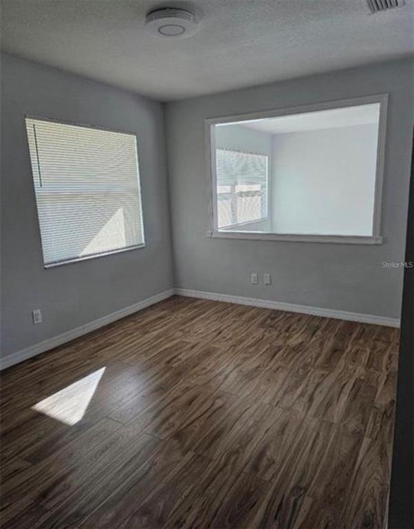 7149 Carmel Avenue New Port Richey, FL 34655 - Photo 10 of 13 a view of an empty room with wooden floor and a window
