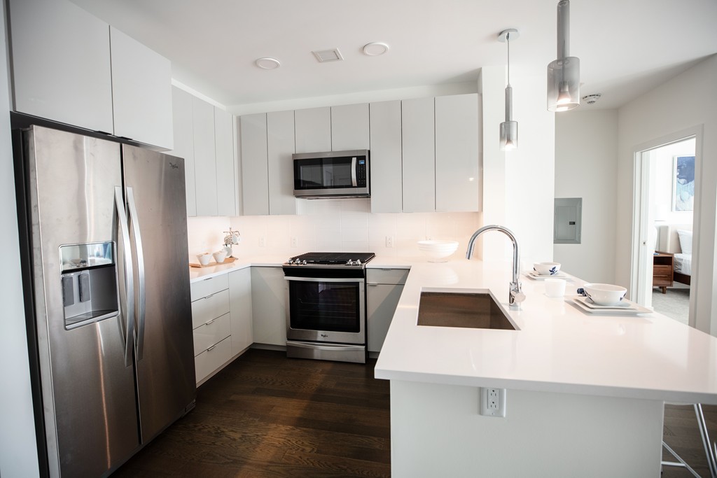 45 Lewis Street, Unit 116 Boston, MA 02128 - Photo 20 of 26 a kitchen with stainless steel appliances a microwave a sink a stove and refrigerator