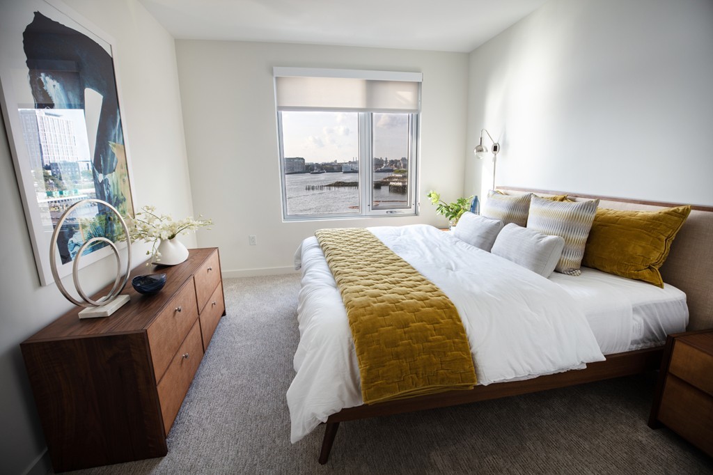 45 Lewis Street, Unit 116 Boston, MA 02128 - Photo 21 of 26 a bedroom with a bed a dresser with mirror