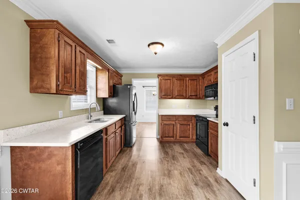a kitchen with a sink stove top oven and refrigerator