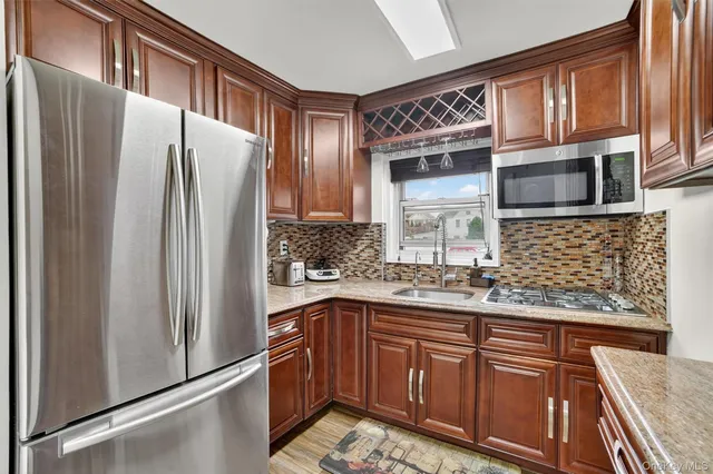 a kitchen with stainless steel appliances granite countertop a refrigerator and a sink
