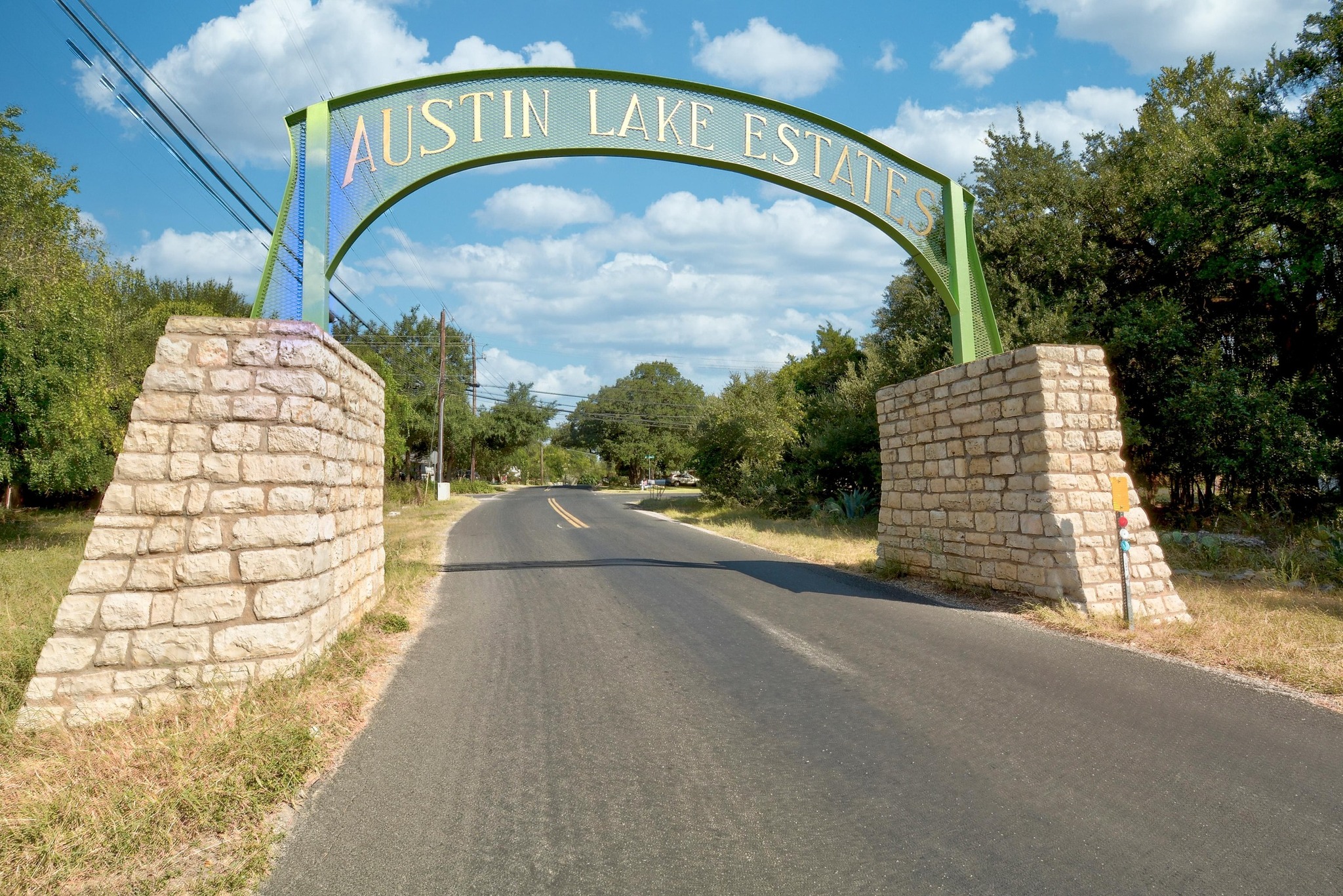 1107 Bowie Road Austin, TX 78733 - Photo 37 of 40 A welcoming stone and metal archway marks the entry to Austin Lake Estates, framed by mature trees.
