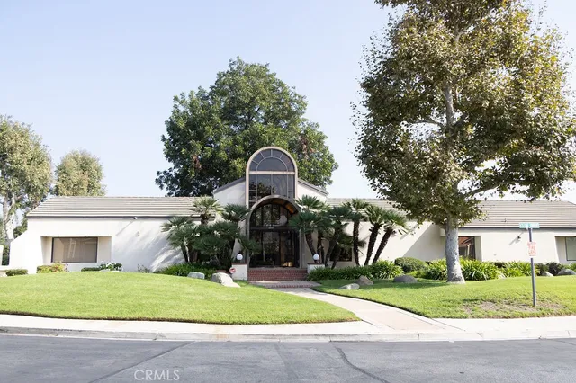 a front view of a house with a garden and trees