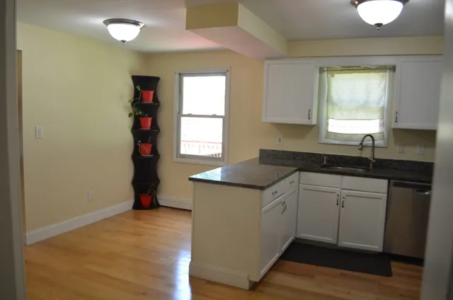 a kitchen with granite countertop a sink cabinets and a window