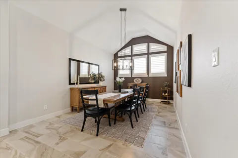 a spacious bedroom with a bed a chandelier and a large window