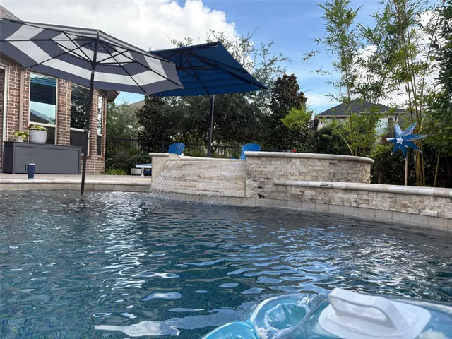 a view of a patio with a table and chairs under an umbrella