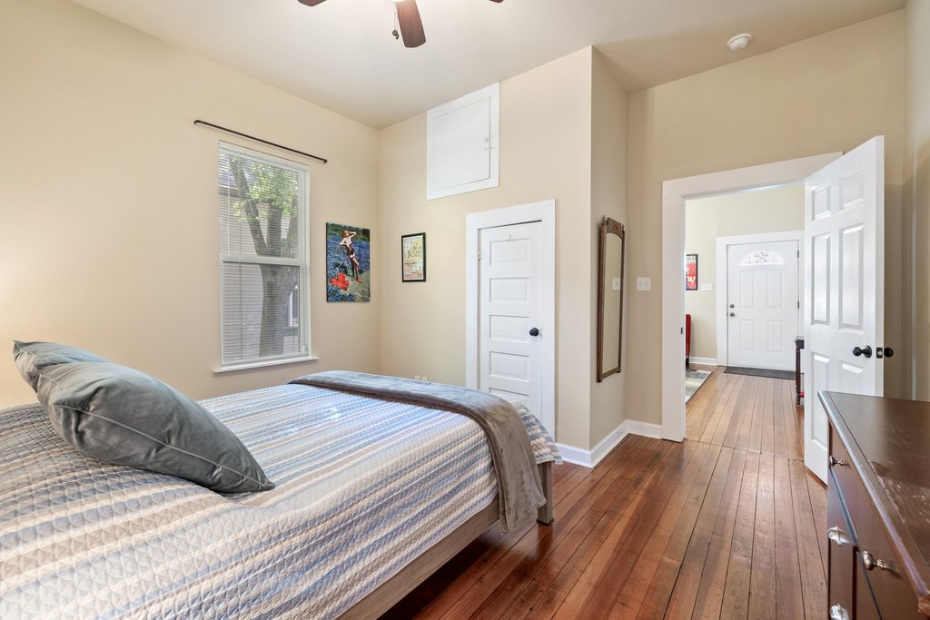 312 West 3rd Street Taylor, TX 76574 - Photo 25 of 33 a bedroom with a bed and wooden floor