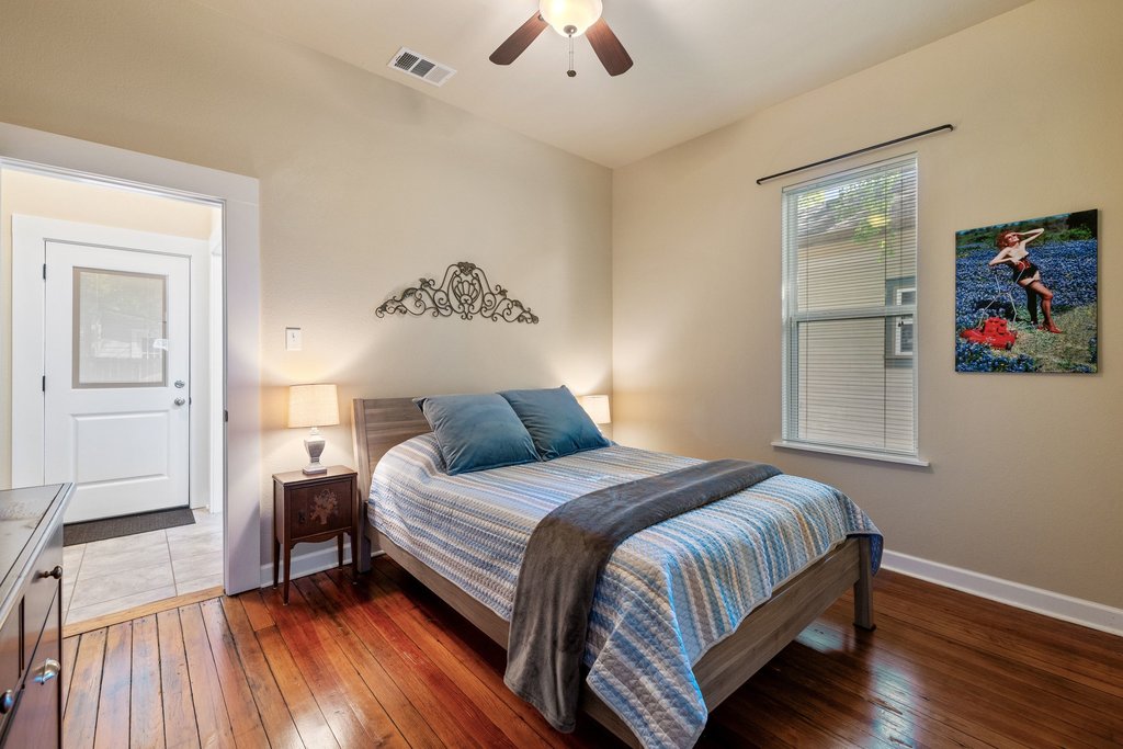 312 West 3rd Street Taylor, TX 76574 - Photo 26 of 33 a bedroom with a bed and a chandelier