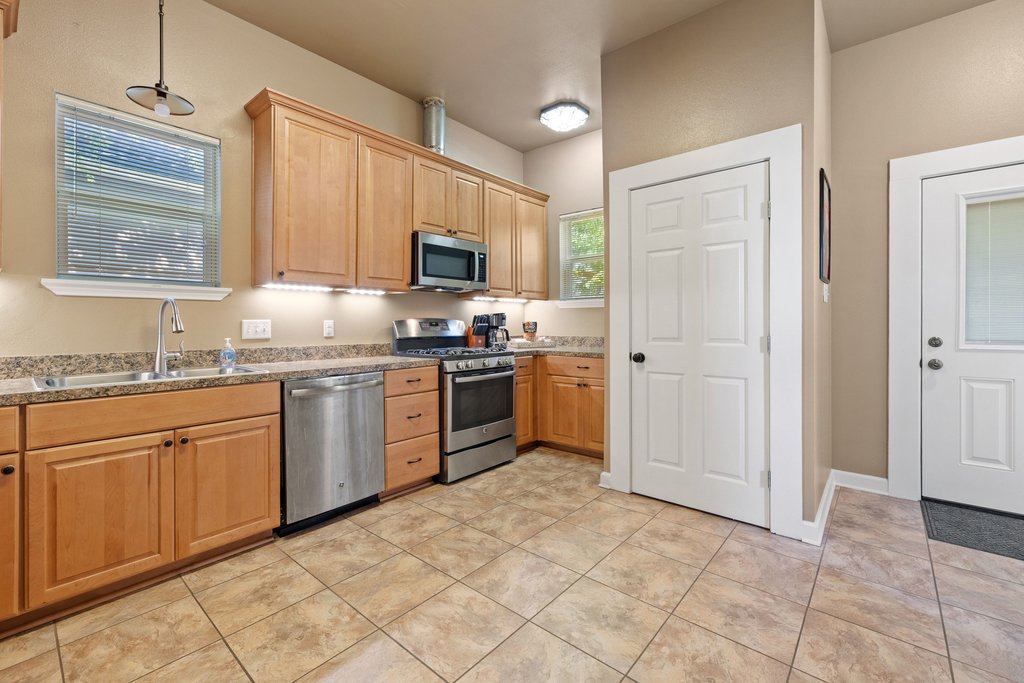 312 West 3rd Street Taylor, TX 76574 - Photo 8 of 33 a kitchen with stainless steel appliances granite countertop a sink cabinets and window