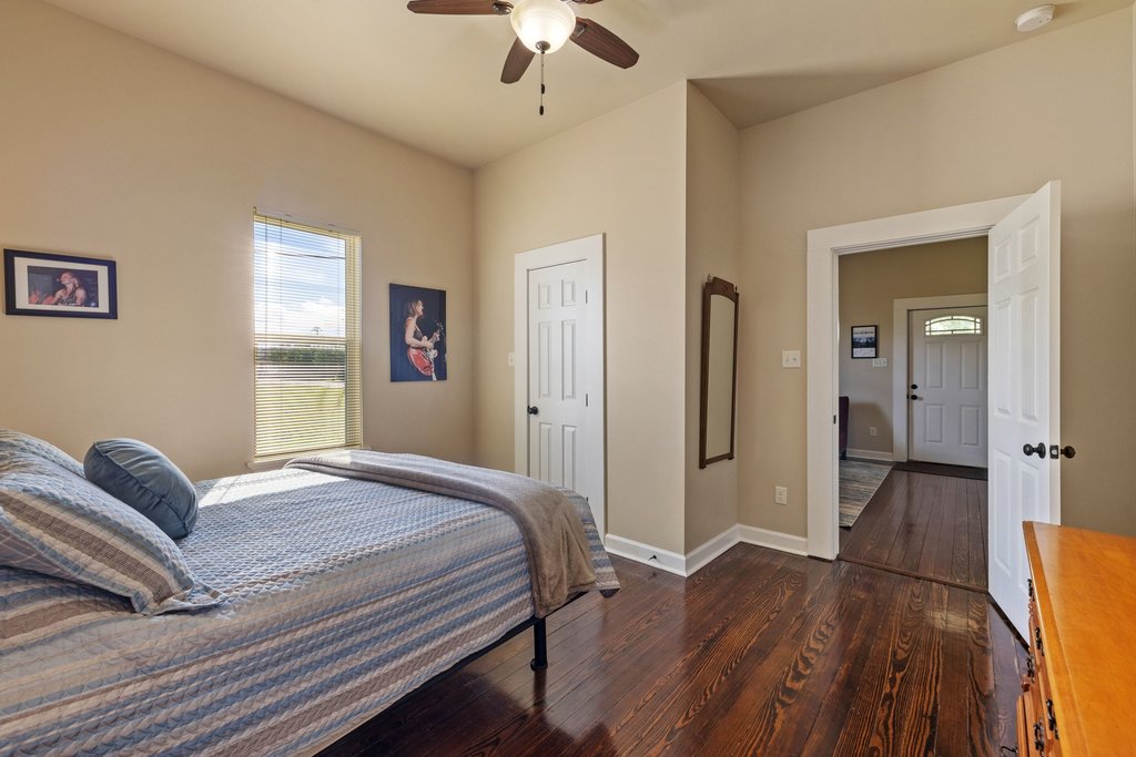 312 West 3rd Street Taylor, TX 76574 - Photo 10 of 33 a bedroom with a bed and wooden floor