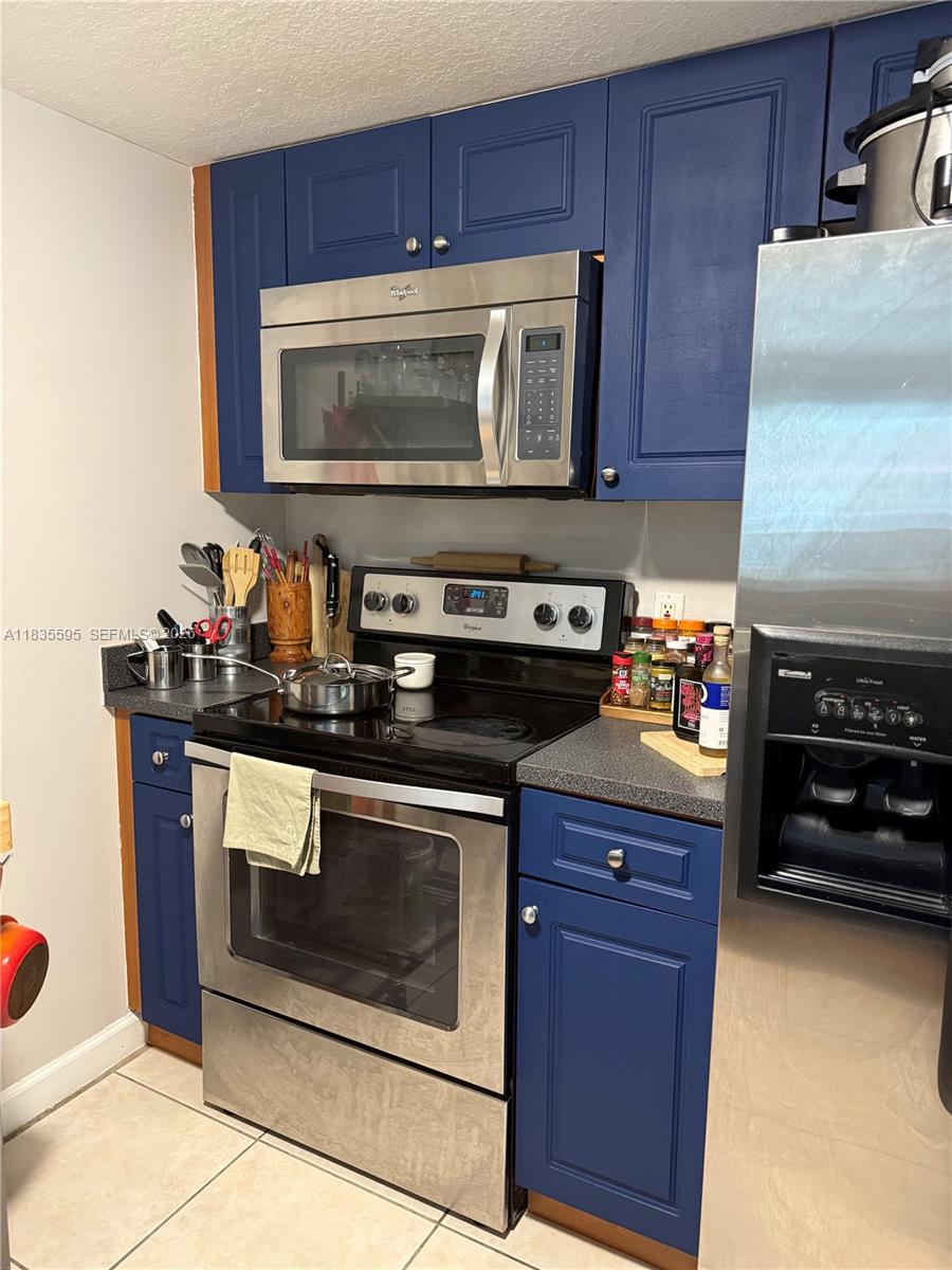 280 Southwest 20th Road, Unit 404 Miami, FL 33129 - Photo 13 of 19 a kitchen with granite countertop a stove and a microwave