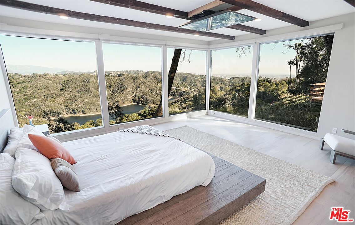 2270 Stradella Road Los Angeles, CA 90077 - Photo 12 of 29 a bed sitting in a bedroom next to a large window