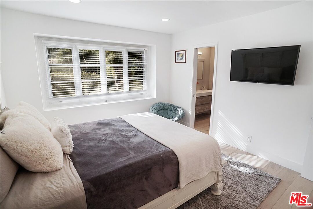 2270 Stradella Road Los Angeles, CA 90077 - Photo 23 of 29 a spacious bedroom with a bed and a television