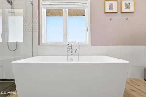 a spacious bathroom with a double vanity sink a mirror and a bathtub