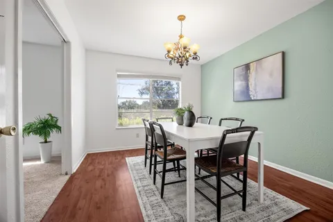 a view of a dining room with furniture wooden floor and a chandelier