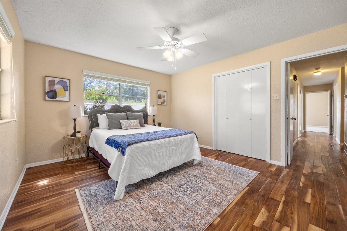 9504 Flintrock Circle Austin, TX 78737 - Photo 20 of 31 a bedroom with a large bed and a chandelier