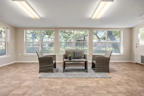 a dining room with furniture and large windows
