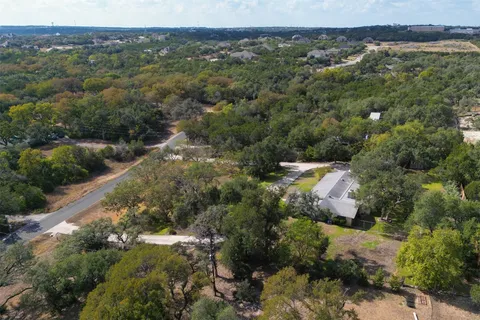 an aerial view of residential houses with outdoor space and trees