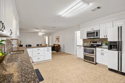 a kitchen with granite countertop a sink and steel appliances