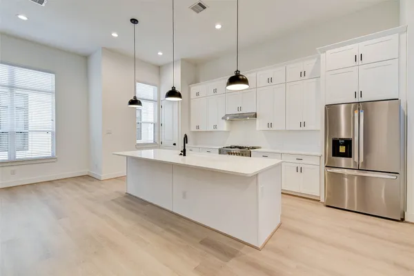 a kitchen with white cabinets and stainless steel appliances