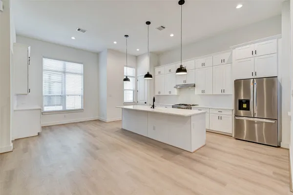 a large kitchen with white cabinets stainless steel appliances and a window