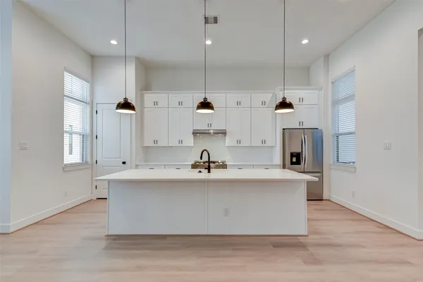 a large kitchen with kitchen island a sink stainless steel appliances and cabinets
