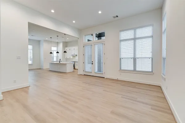 a view of empty room with wooden floor and windows