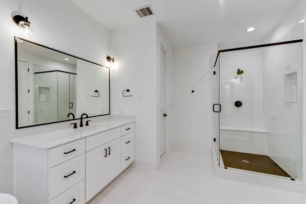 a bathroom with a double vanity sink and mirror with shower