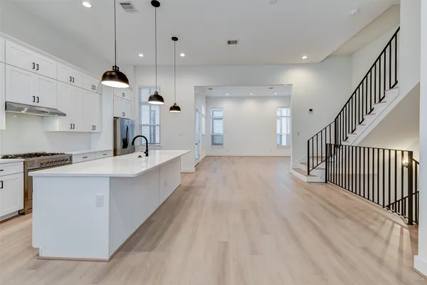 a kitchen with kitchen island a sink and a stove top oven