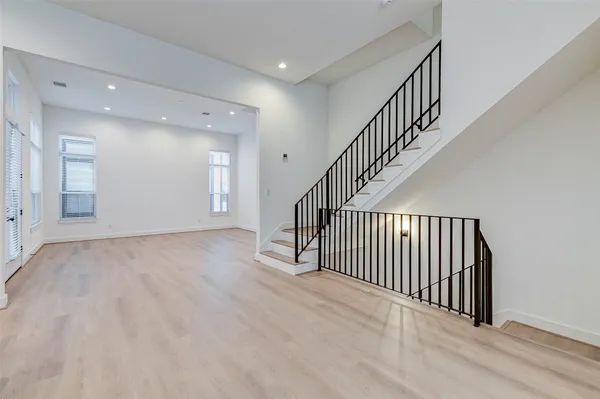 a view of a hallway with wooden floor and entryway