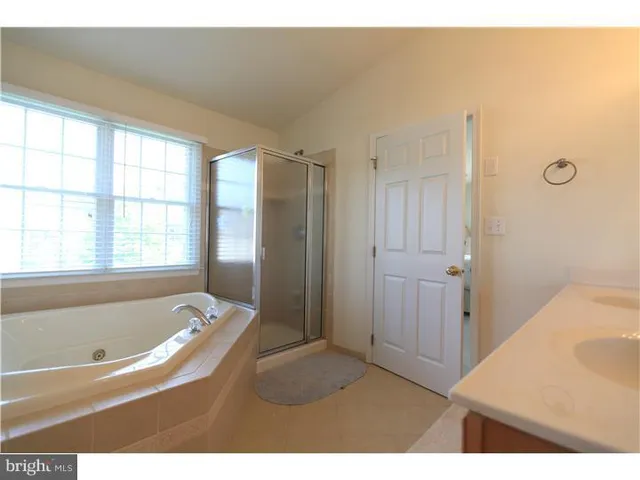 a bathroom with a tub shower and sink