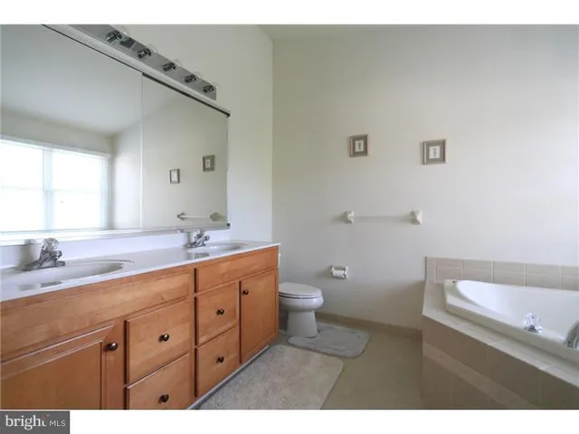 a bathroom with a granite countertop sink mirror and toilet