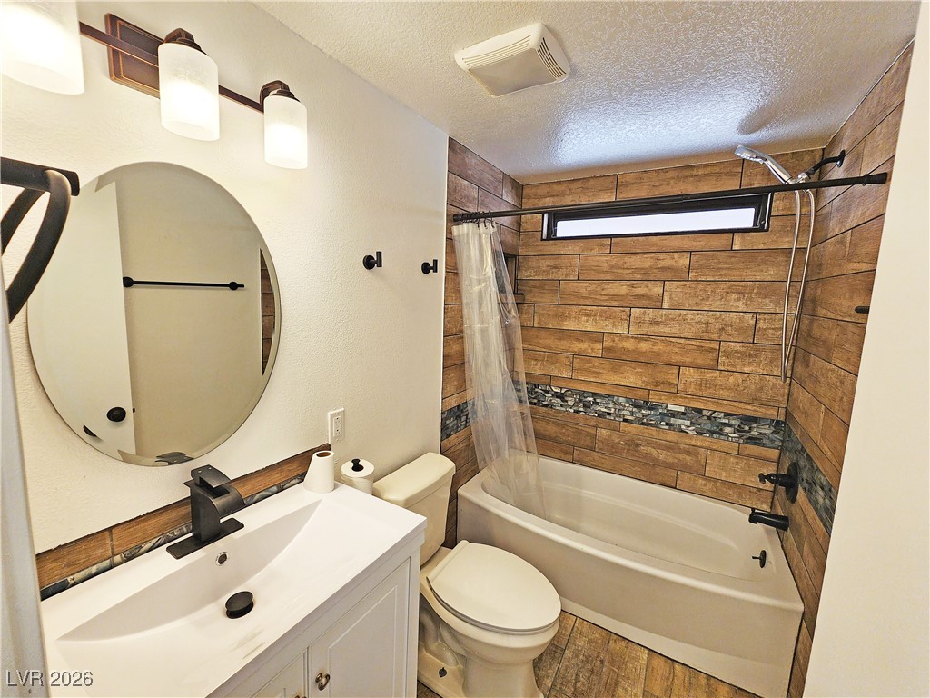 1860 West Wilson Road Pahrump, NV 89048 - Photo 8 of 16 Bathroom with vanity, a textured ceiling, shower / bath combo, and wood finished floors