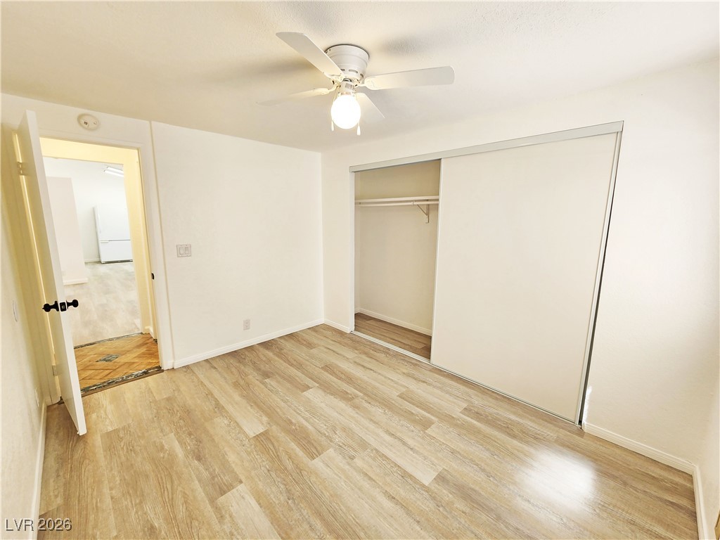 1860 West Wilson Road Pahrump, NV 89048 - Photo 10 of 16 Unfurnished bedroom featuring light wood-type flooring, ceiling fan, and a closet