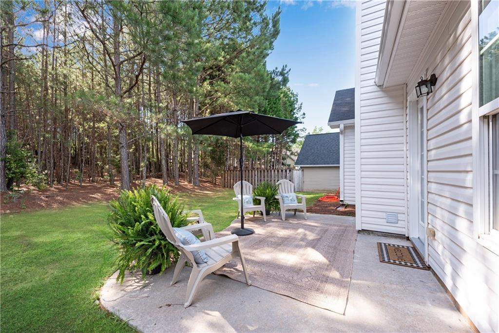 125 Pine Ridge Trace Athens, GA 30605 - Photo 22 of 28 a view of a patio with table and chairs under an umbrella with large trees