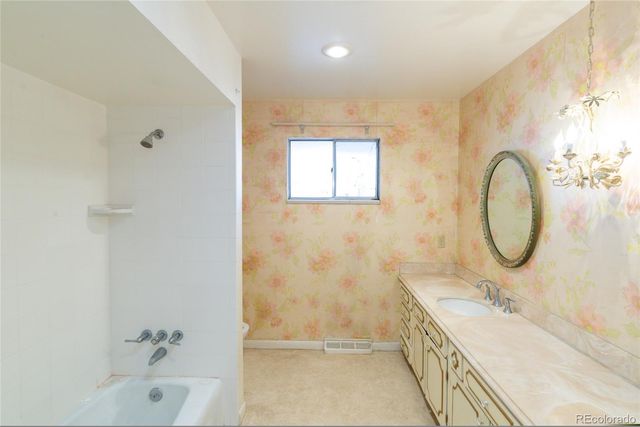a bathroom with a tub sink and mirror