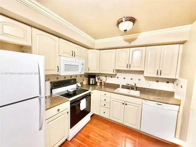 a kitchen with granite countertop cabinets stainless steel appliances and a sink